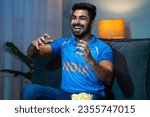 Small photo of Emotional Young man Celebrating Indian cricket team victory while watching on tv at home - concept of Winning Happiness, Emotional moments and entertainment.