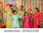 Small photo of Group of family members dancing together during diwali festive celebration gathering at home - concept of entertainment, Holiday reunion and enjoyment