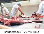 group of butchers works in a slaughterhouse and cuts freshly slaughtered meat (beef and pork) for sale and further processing as sausage