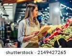 Small photo of Woman working at a grocery store doing the inventory - small business concepts