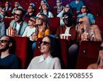 Small photo of An excited diverse crow is in the movie theater enjoying a 3D movie on the big screen.