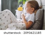 Little girl use inhaler nebulizer lying in bed in bedroom. Child asthma inhaler, nebulizer steam, flu or cold concept. Copyspace