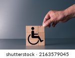 Small photo of concept of equality for handicapped people in the work place and in life . hand posing wooden block with handicap symbol