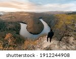 Man standing in front of Vyhlídka Máj the horseshoe shaped river in the south of Prague, czech republic with a wonderful sunset.