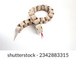 a snake made out of toilet paper rolls, craft made of recycle cardboard, DIY, tutorial, educational art for kids, paper chain python toy on white background