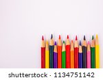 Small photo of Assorted color map coloring pencils framed lower right on solid background