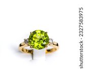 Small photo of A vibrant peridot gemstone graces the center of a glossy, tarnish-resistant, yellow gold ring. The ring is accented with multiple pave-set diamonds, sparkling exquisitely to complement the main stone