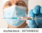 Small photo of Doctor holding syringe with Covid-19 vaccine with inscription booster shot. Concept of third booster dose of vaccine