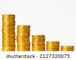 Small photo of Stacks of golden coins forming going down graph on the white background. Concept of regression in finance, investment, crisis, low GDP rate of the country