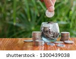 Small photo of Woman hand putting coinIn the glass jar. Saving money wealth and financial concept, Personal finance, finance management, savings, thrifty or avarice concept