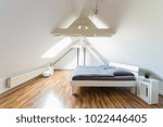 Small photo of Bright, modern maisonette bedroom with double bed, wide angle view, puristic attic bedroom, gray bedclothes