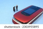 Small photo of Miniature People Mourning Beside Outdated Cell Phone.