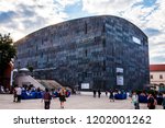 Small photo of Vienna, Austria - June 14, 2014: Sunrays above the Mumok museum. People moving between MQ social zones. Museumsquartier or MQ is a large area in the city of Vienna, Austria