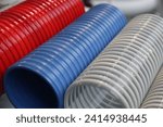 Small photo of Modern colorful plastic spiral hoses closeup. Helical polymer wire reinforced ventilation pipes