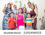 Cheerful indian asian generational family celebrate indoor birthday party.