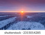 Small photo of The northern sun is low on the horizon. Landscape of winter taiga. Russian winter of northern latitudes from a drone.