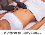 Cosmetic injection in the spa salon. Beautician makes injection into the patient's belly. the concept of rejuvenation.