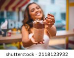 Young afro woman holding a milkshake in her hand. Woman with a milkshake