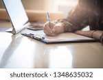 Small photo of Sign on the dotted line. Business woman writing on document. close up. Focus on hand.