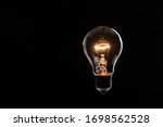 tungsten light bulb lit on black background