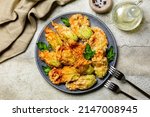 Italian appetizer. Fried in a batter Zucchini Flowers stuffed with ricotta cheese and parsley. Roasted courgette or pumpkin flowers. Fiori di zucca in pastella. Stone background.
