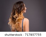 Woman with Long Healthy Colorful Ombre Wavy Hair. Close Up of Hairstyle. Care and Hair Products