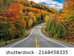Small photo of Highway through the autumn forest in the mountains. Autumn forest highway road. Highway in autumn forest. Beautiful autumn forest highway road landscape