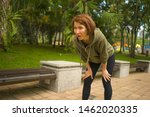Small photo of outdoors portrait of young attractive tired and breathless jogger woman in breathing exhausted after running workout at beautiful city park in fitness sport training and healthy lifestyle concept