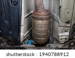 Small photo of A diesel particulate filter in the exhaust system in a car on a lift in a car workshop, seen from below.