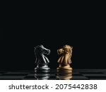 Small photo of The confront between golden and silver horses, knight chess piece standing together on chessboard on dark background. Leadership, partnership, competitor, competition, and business strategy concept.