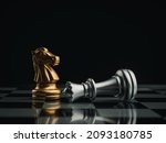 The golden horses, knight chess piece standing near the loser silver queen chess piece who fell on chessboard background. Leadership, winner, loser, competition, and business strategy concept.