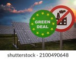 Green deal sign in front of photovoltaic panels. Renewable and alternative power generation. Ecology concept.