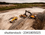 Small photo of Aerial view directly above a crane or mechanical digger with grab loading a dumper truck with earth and soil in the construction industry on a brownfield site with copy space