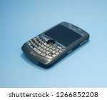 Small photo of Indonesia - December 2018 : Blackberry 8310 Titanium Grey, used and broken isolated on blue background