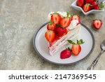 Dessert, sliced sponge cake with custard, fresh strawberries and whipped cream on a gray concrete background. Swedish cuisine. Strawberry recipes