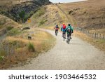 Small photo of Three people cycling the Otago Central Rail Trail with Rockfall Hazard sign by the track side, at Daisybank, between Waipiata and Middlemarch, South Island