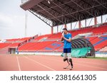 Small photo of Asian para-athlete with prosthetic blades taking a break after exercise. Attractive amputee male runner exercise and practicing workout for Paralympics competition regardless of physical limitations.