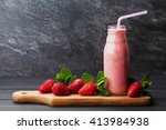 Strawberry smoothie or milkshake in jar on black rustic background, healthy food for breakfast and snack