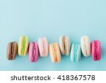 Cake macaron or macaroon on turquoise background from above, colorful almond cookies, pastel colors, vintage card, top view