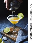 Small photo of Bartender making margarita cocktail.Close up of classic lime margarita coctail with salt served in martini glass.