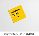 Small photo of Inscription welcome back on the sticky note with red color pen on the office wooden desk. Praise from colleagues or boss. Positive compliment concept.
