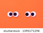 Googly eyes: One pair strabismus and squint mad googly eyes and one pair normal funny eyes next to each other on a orange background.