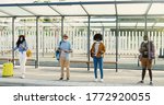 Small photo of Mixed-races young males and females people im medical masks standing in line at bus stop. Keeping safe social distance. Multiethnic stylish men and women tourists outdoor waiting for transport.