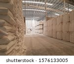 Small photo of Landscape inside a warehouse with white color tons of sack or bag stacking up under the roof. Agricultural products being processed and ready for the export shipment. Industrial and factory concept.