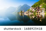 Scenic panoramic view of famous Hallstatt lakeside town reflecting in Hallstattersee lake in the Austrian Alps in scenic morning light on a beautiful sunny day in summer, Salzkammergut region, Austria