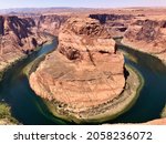 Small photo of Horseshoe Bend is the name of the place where the Colorado River entrenched in the shape of a horseshoe near the town of Page, Arizona, United States.The boat floating on the river looks small.