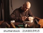 Small photo of portrait tanner makes leather wallet, professional craftsman, business. Handiwork.