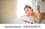 Small photo of The skilled hands of the professional masseuse glided over the back of the beautiful asian woman providing a soothing and relaxing massage experience on the bed adorned with scattered roses.