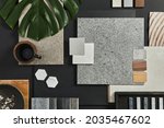 Flat lay of creative architect moodboard composition with samples of building, textile and natural materials and personal accessories. Top view, black backgroung, template.