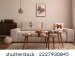 Domestic and cozy interior of living room with mock up poster frame, modern beige sofa, oval wooden coffee table, round pillows, lamp, vintage rug, floor, lamp and personal accessories. Template